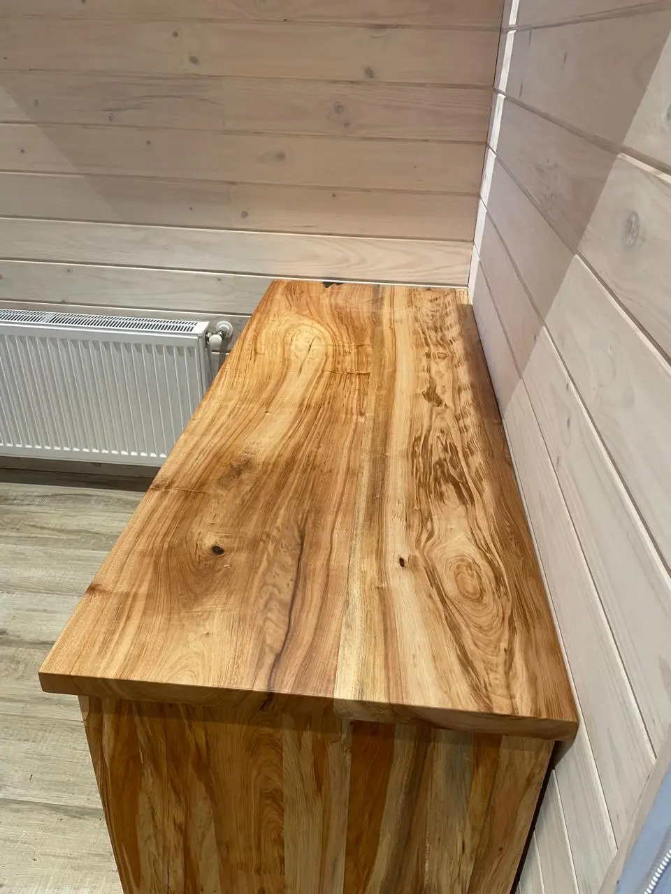 Mesón de madera maciza con veta natural pronunciada, instalado a medida