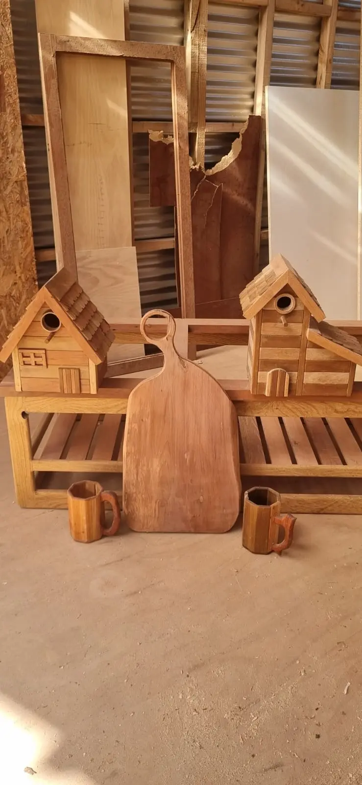 Conjunto de piezas artesanales en madera: casas de pájaro, tabla de cortar y jarros torneados