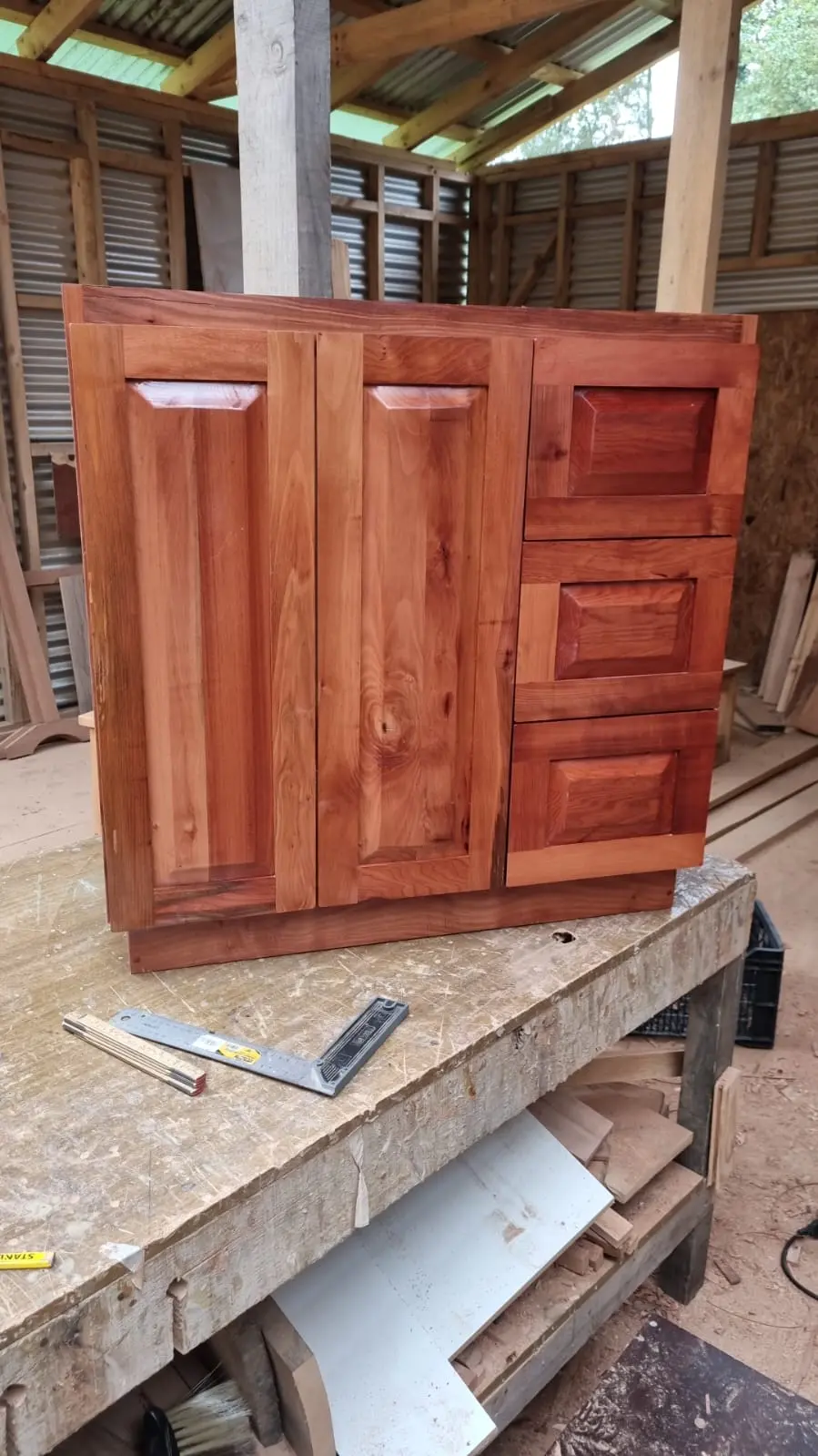 Mueble bajo a medida con dos puertas y tres cajones en madera nativa raulí, terminado en taller